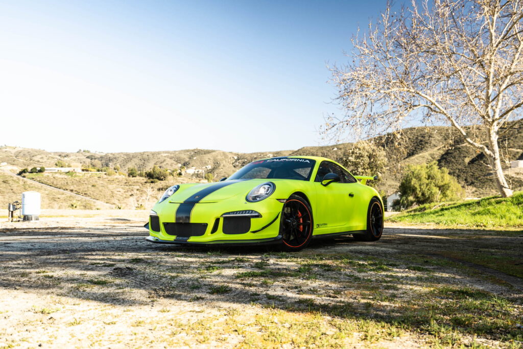 Porsche 911 GT3 in a gloss lime yellow color-change wrap with black stripes by California Motorsports