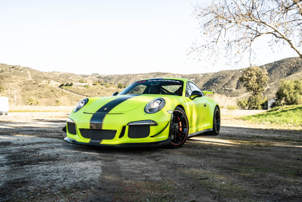 Porsche 911 GT3 in a gloss lime yellow color-change wrap with black stripes by California Motorsports