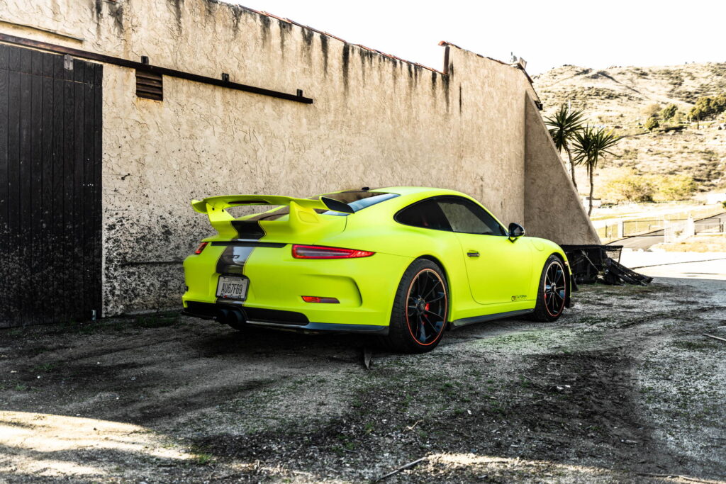 Porsche 911 GT3 in a gloss lime yellow color-change wrap with black stripes by California Motorsports