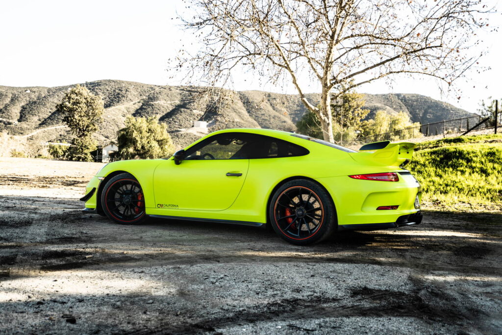 Porsche 911 GT3 in a gloss lime yellow color-change wrap with black stripes by California Motorsports
