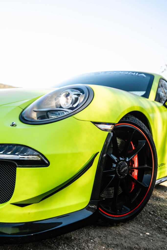 Porsche 911 GT3 in a gloss lime yellow color-change wrap with black stripes by California Motorsports