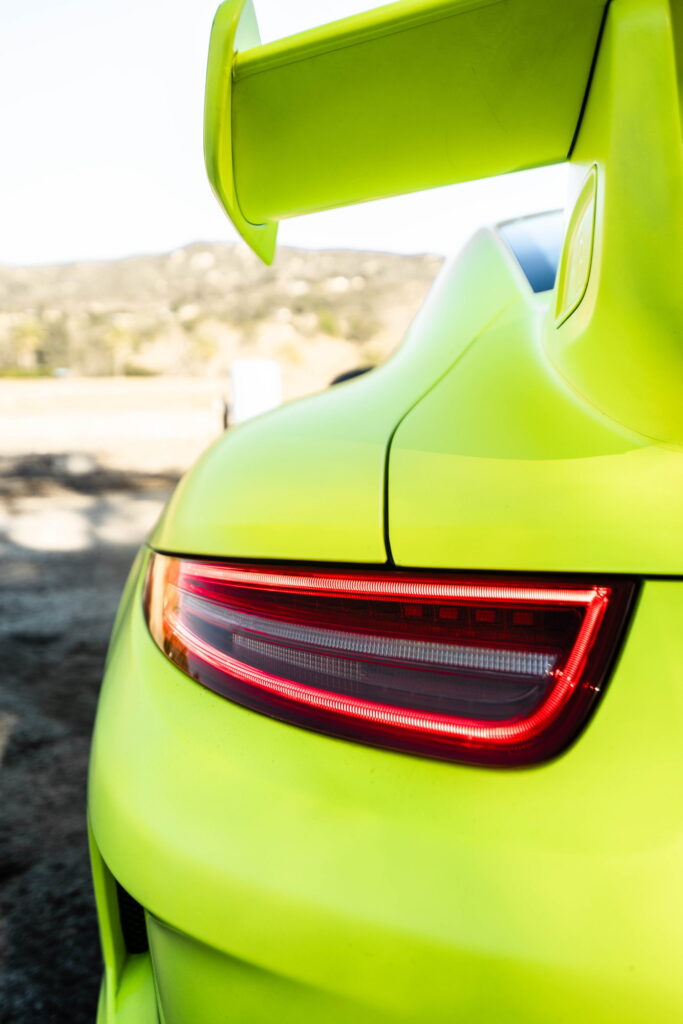 Porsche 911 GT3 in a gloss lime yellow color-change wrap with black stripes by California Motorsports