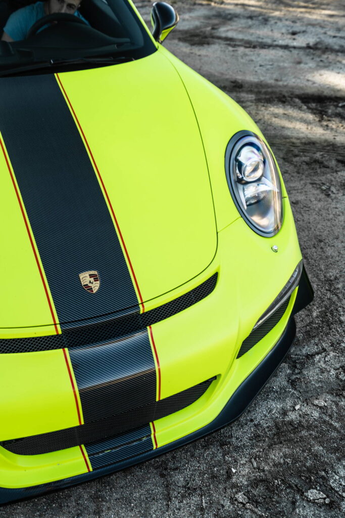 Porsche 911 GT3 in a gloss lime yellow color-change wrap with black stripes by California Motorsports