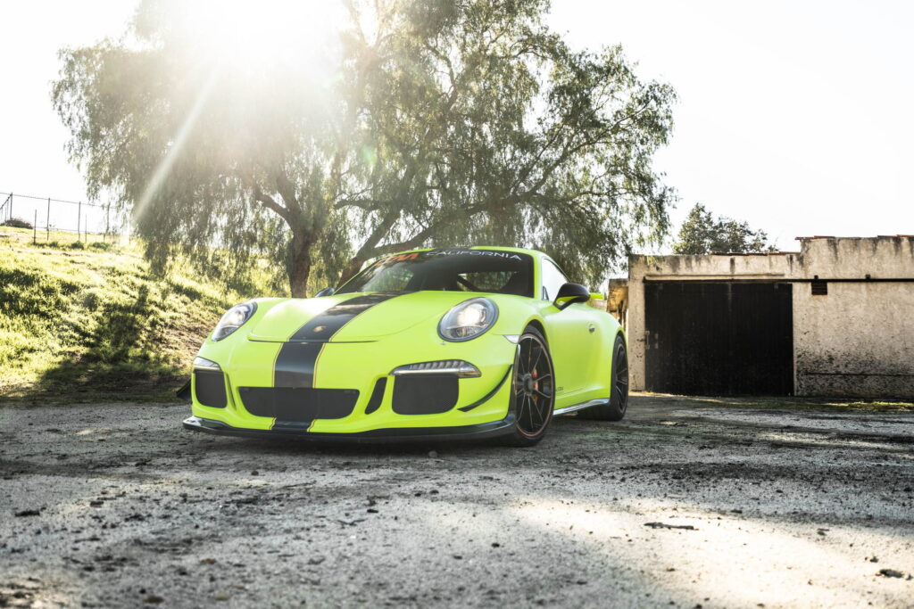 Porsche 911 GT3 in a gloss lime yellow color-change wrap with black stripes by California Motorsports