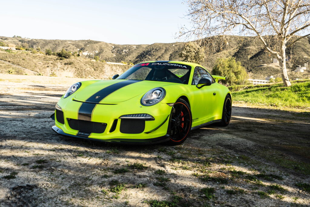 Porsche 911 GT3 in a gloss lime yellow color-change wrap with black stripes by California Motorsports